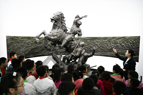 2019年4月4日,在东北烈士纪念馆,学生们在听讲解员讲解。